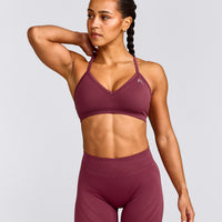 EnhanceLift™ Seamless Strappy Sports Bra with Grey Logo | Burnt Maroon Red