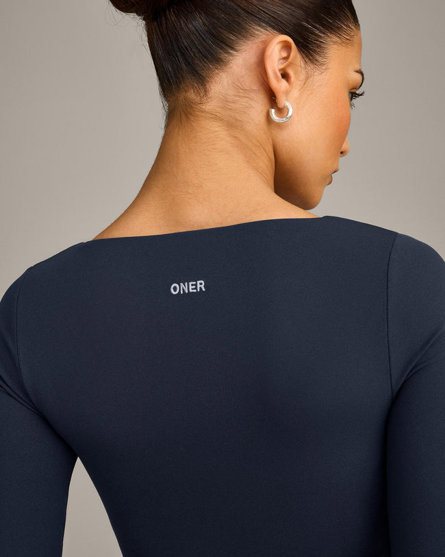 SoftMotion™ Scoop Neck Long Sleeve Crop Top with Built in Bra Shelf with Grey Logo | True Blue