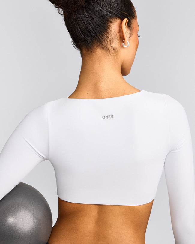 SoftMotion™ Scoop Neck Long Sleeve Crop Top with Built in Bra Shelf with Grey Logo | White